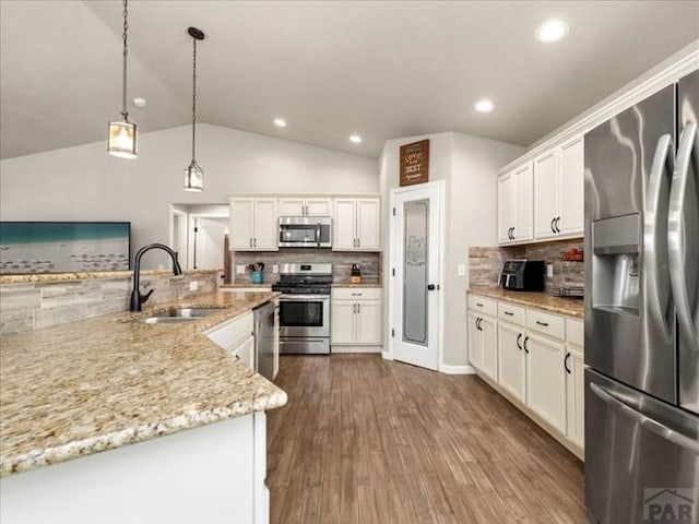 kitchen featuring dark wood-style floors, lofted ceiling, appliances with stainless steel finishes, white cabinetry, and a sink