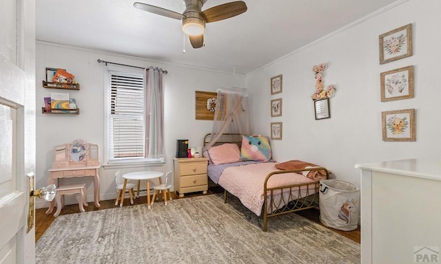 bedroom featuring ornamental molding, ceiling fan, and wood finished floors