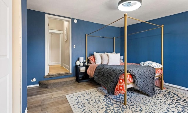 bedroom with baseboards and wood finished floors