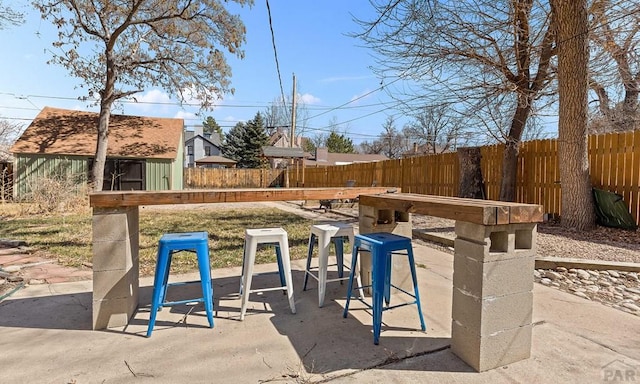 view of patio / terrace featuring an outdoor structure and fence