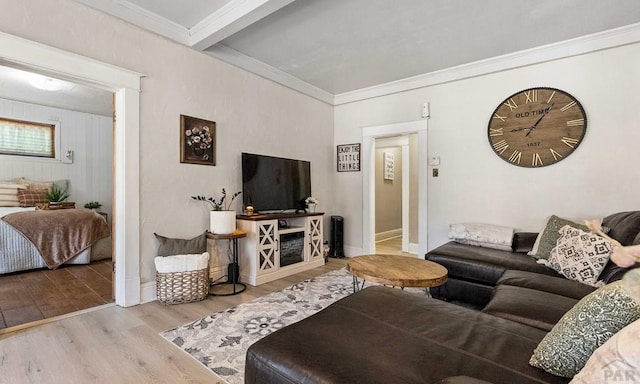 living area with crown molding, wood finished floors, and baseboards