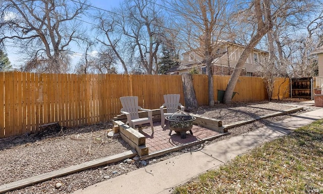 view of yard with a patio, a fenced backyard, and an outdoor fire pit