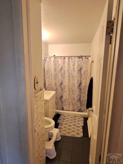 1622 Zuni Rd, Pueblo, CO 81001 - bathroom featuring tile patterned flooring, toilet, and a shower with curtain