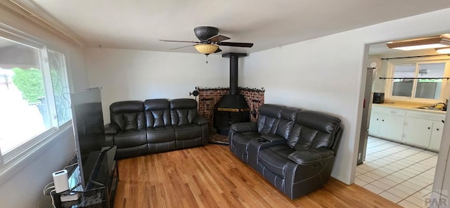 1622 Zuni Rd, Pueblo, CO 81001 - living room with ceiling fan, a wood stove, and light tile patterned floors