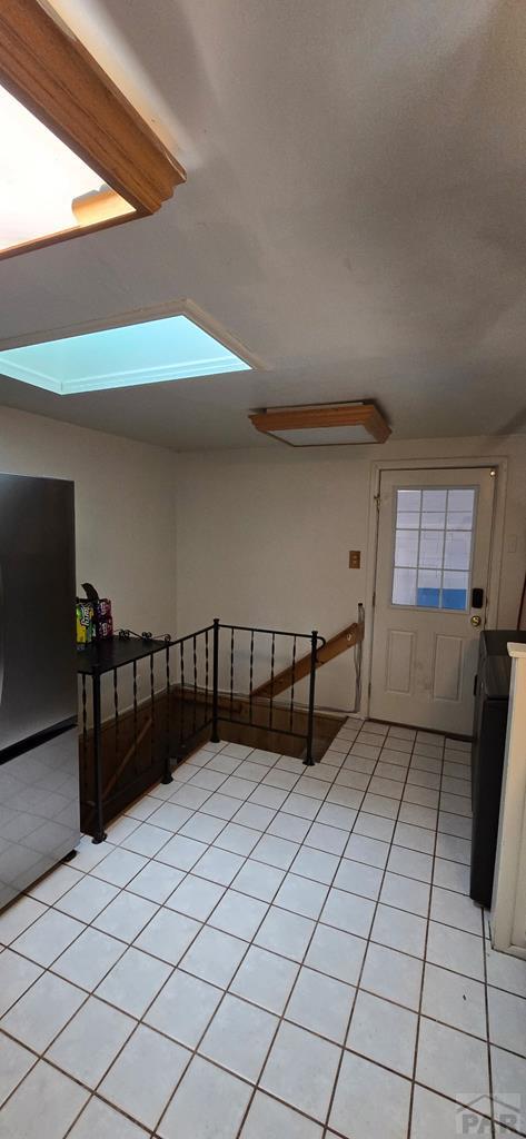 1622 Zuni Rd, Pueblo, CO 81001 - kitchen featuring a skylight and freestanding refrigerator