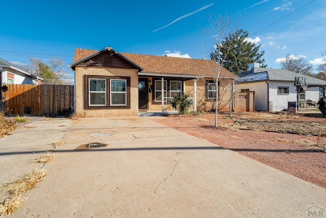 view of front of house featuring a shingled roof and fence