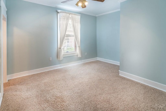 spare room with a ceiling fan, baseboards, and crown molding