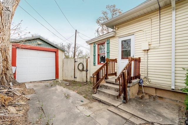 entrance to property featuring fence, driveway, and a garage