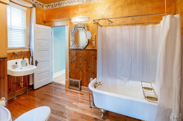 full bathroom featuring wood finished floors, visible vents, vanity, a bathtub, and a shower with shower curtain