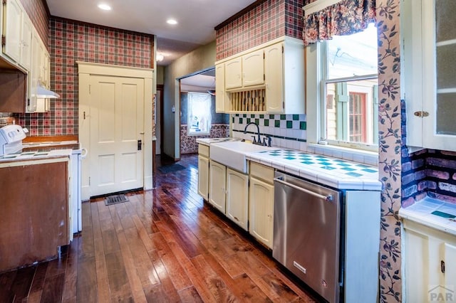 kitchen featuring a sink, backsplash, tile counters, white range with electric cooktop, and dark wood-type flooring