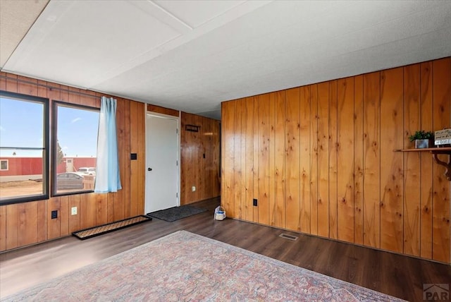 37155 E Jones Rd, Yoder, CO 80864 - unfurnished room with wooden walls, wood finished floors, and visible vents