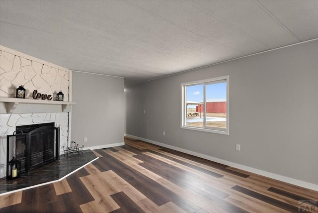 37155 E Jones Rd, Yoder, CO 80864 - unfurnished living room featuring visible vents, baseboards, wood finished floors, and a fireplace
