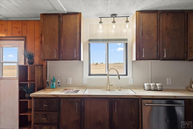 37155 E Jones Rd, Yoder, CO 80864 - kitchen with light countertops, dark brown cabinets, stainless steel dishwasher, and a sink
