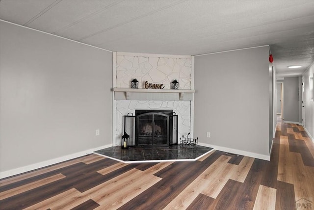 37155 E Jones Rd, Yoder, CO 80864 - unfurnished living room with baseboards, wood finished floors, and a large fireplace