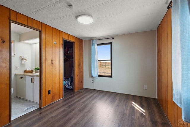 37155 E Jones Rd, Yoder, CO 80864 - unfurnished bedroom featuring visible vents, wood finished floors, wooden walls, and a closet