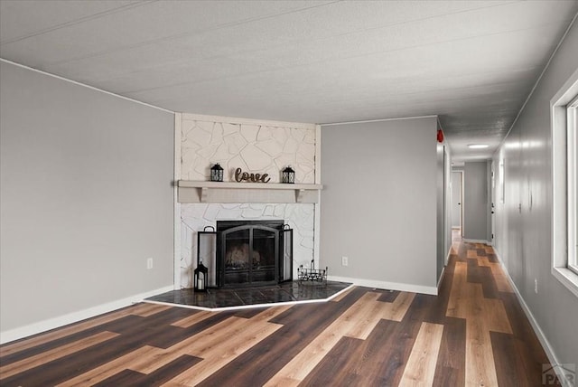 37155 E Jones Rd, Yoder, CO 80864 - unfurnished living room featuring baseboards, wood finished floors, and a fireplace