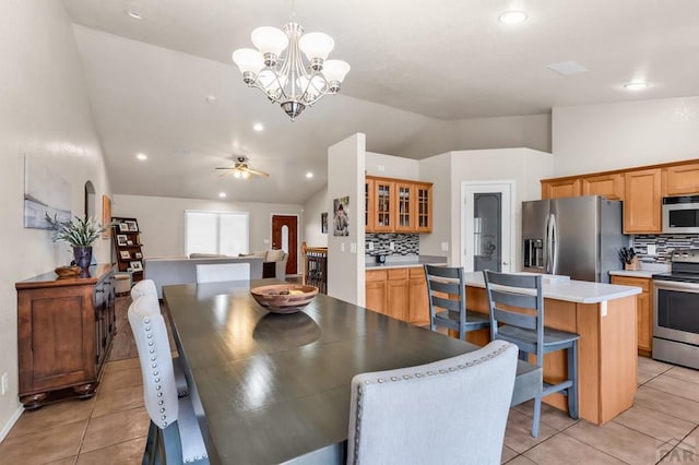 dining space with lofted ceiling, recessed lighting, light tile patterned floors, and ceiling fan with notable chandelier