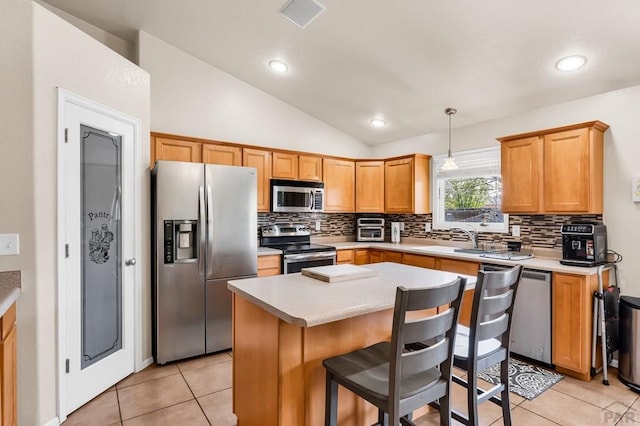 kitchen featuring vaulted ceiling, a sink, decorative backsplash, light tile patterned floors, and stainless steel appliances