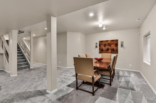 dining space with baseboards, carpet, visible vents, and stairs