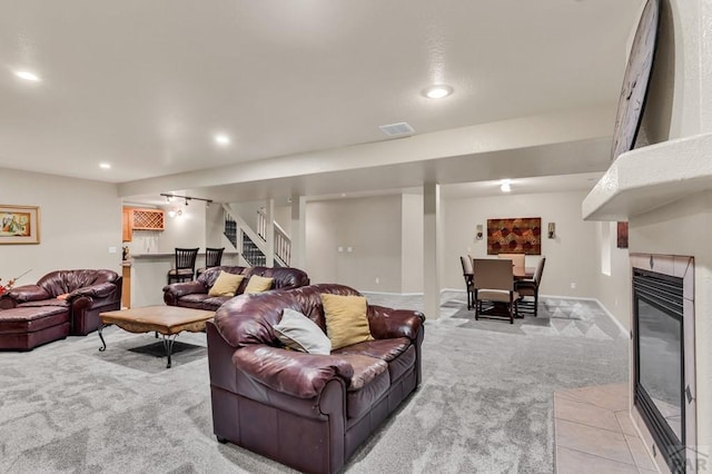 living room featuring visible vents, recessed lighting, light colored carpet, stairs, and a fireplace