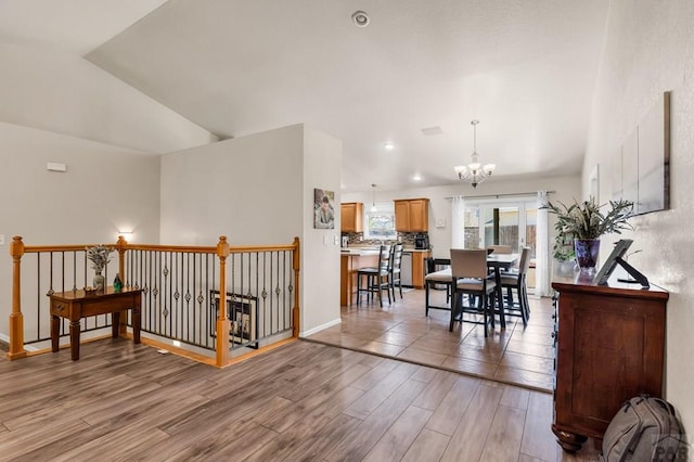 interior space featuring baseboards, recessed lighting, light wood-style floors, a chandelier, and lofted ceiling