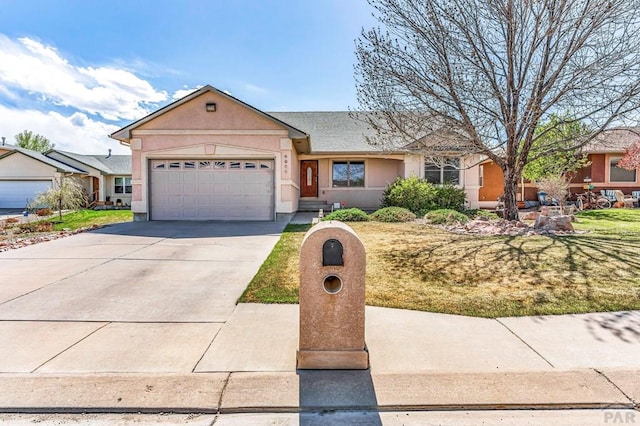 ranch-style home with an attached garage, a front lawn, stucco siding, and driveway