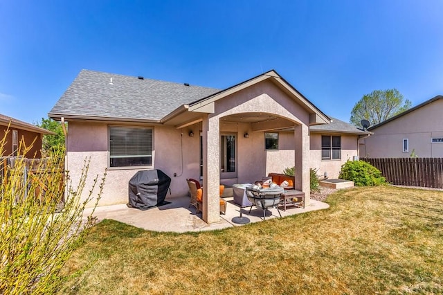 rear view of house with fence, stucco siding, a patio, an outdoor living space, and a lawn