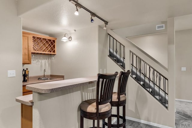 bar with visible vents, a sink, baseboards, stairs, and indoor wet bar