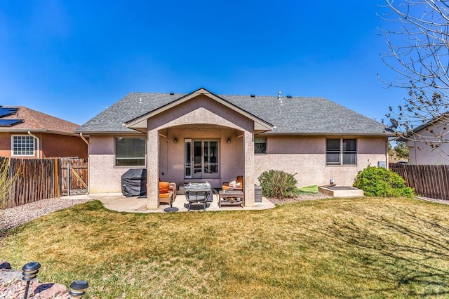 rear view of property featuring a lawn, a fenced backyard, and stucco siding