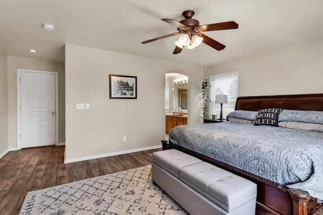 bedroom featuring recessed lighting, arched walkways, wood finished floors, and baseboards