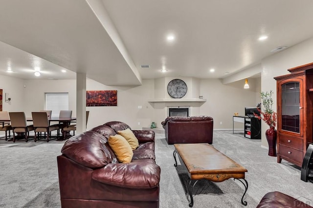 carpeted living room with baseboards, a glass covered fireplace, visible vents, and recessed lighting