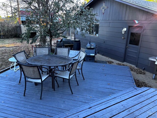 deck featuring outdoor dining space and fence