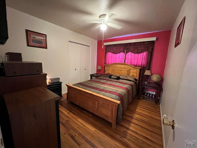 bedroom with dark wood-style floors, a closet, and a ceiling fan