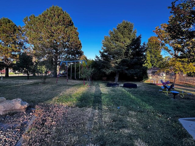 view of yard featuring fence and a playground