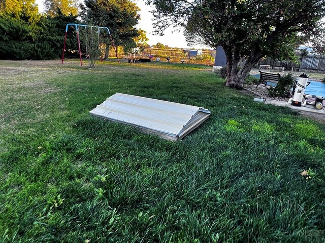 view of storm shelter with a yard and fence