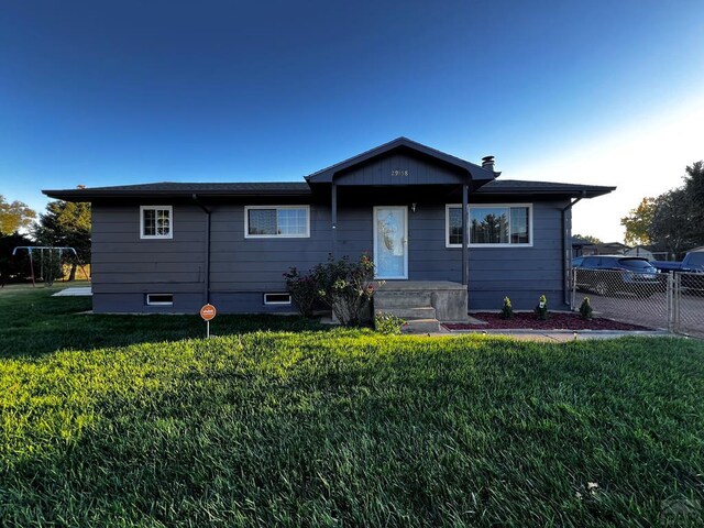 view of front of home featuring fence and a front lawn