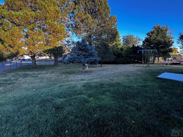 view of yard featuring playground community and fence