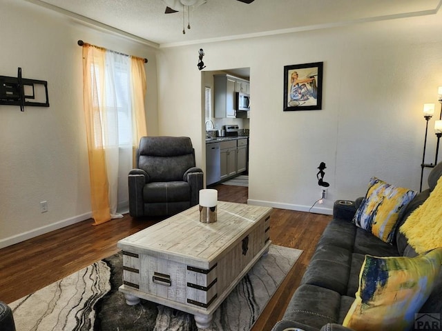 living room with dark wood finished floors, baseboards, and ceiling fan