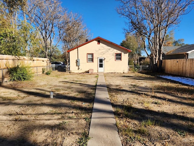 back of property featuring a fenced backyard and stucco siding