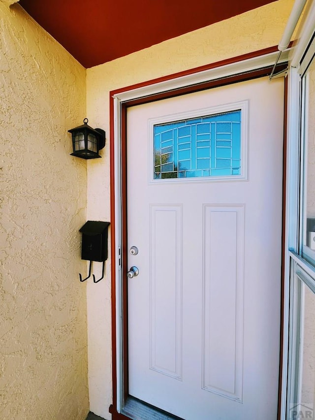 property entrance with stucco siding