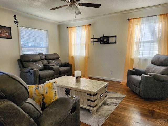 living area featuring a textured ceiling, ceiling fan, wood finished floors, and a wealth of natural light