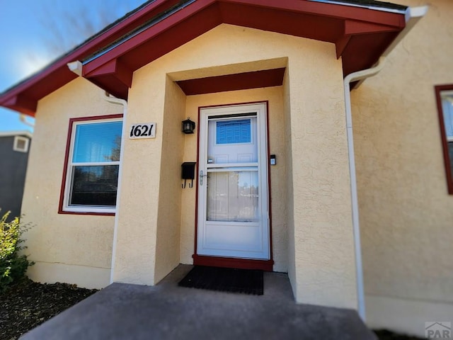 entrance to property featuring stucco siding