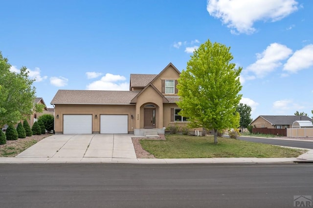 2330 Inspiration Ln, Pueblo, CO 81008 - view of front facade with stucco siding, driveway, a garage, and a front yard