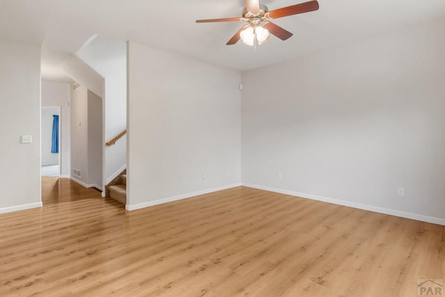 2330 Inspiration Ln, Pueblo, CO 81008 - unfurnished room featuring ceiling fan, light wood-style floors, stairway, and baseboards