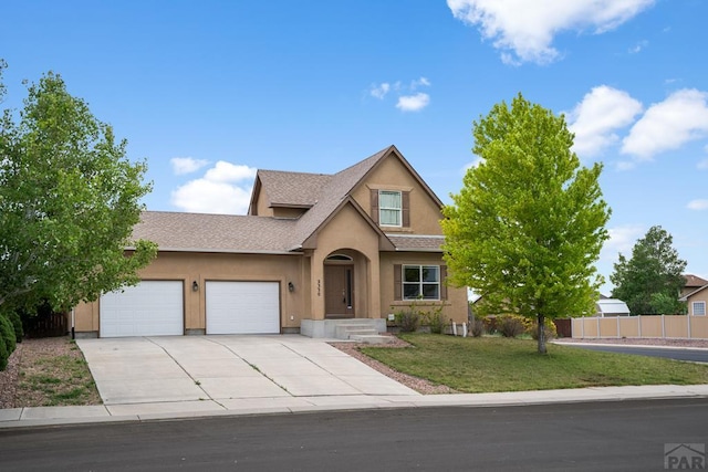 2330 Inspiration Ln, Pueblo, CO 81008 - traditional-style house with an attached garage, stucco siding, driveway, and roof with shingles