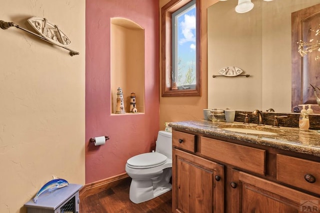 bathroom featuring toilet, wood finished floors, and vanity