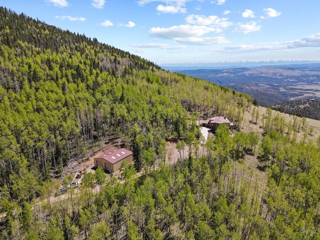 drone / aerial view with a mountain view and a view of trees