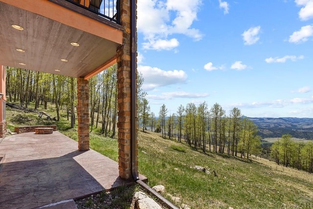 view of yard featuring an outdoor fire pit, a patio, and a balcony