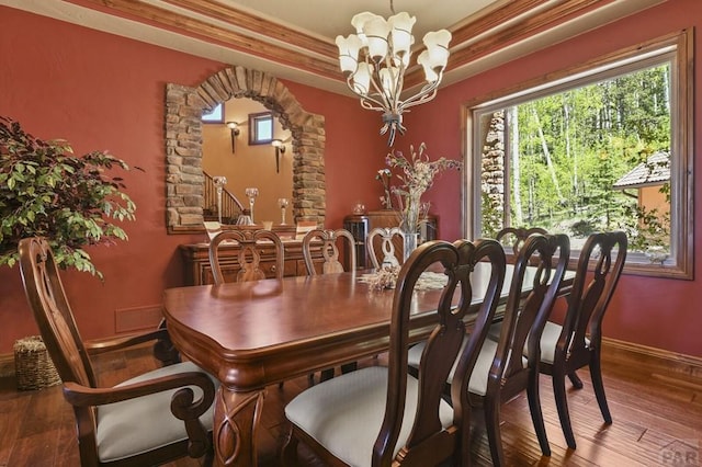 dining area with visible vents, baseboards, arched walkways, wood finished floors, and an inviting chandelier