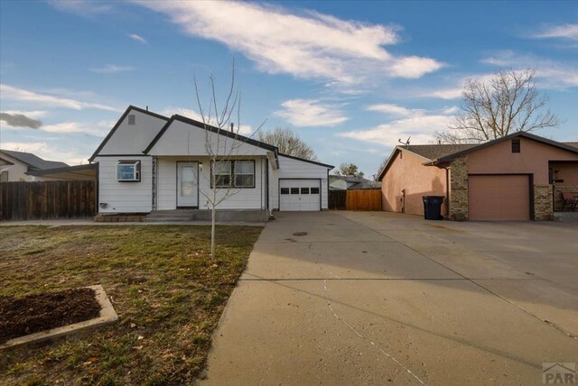 view of front of home with a garage, driveway, fence, and brick siding